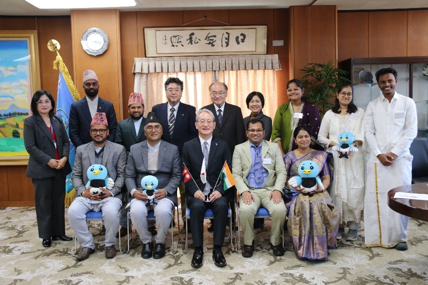Researchers in their traditional attire with President Node and other attendees.