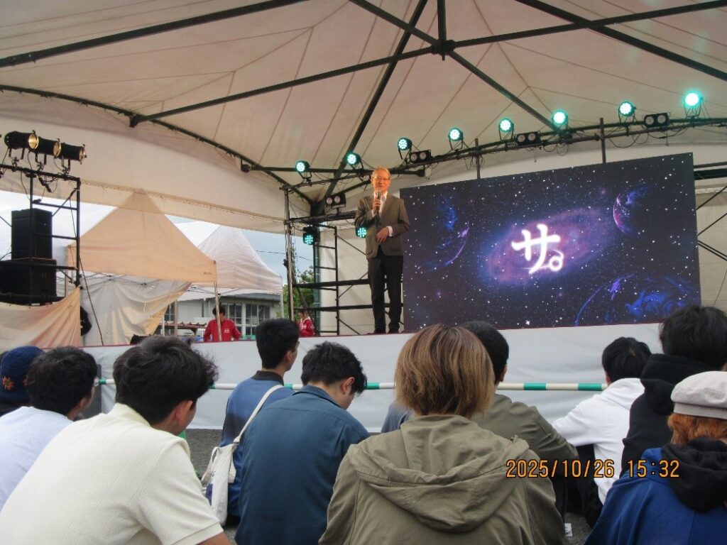 メインステージにて挨拶される野出学長